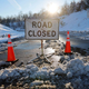 A sign says that the road is closed due to snow